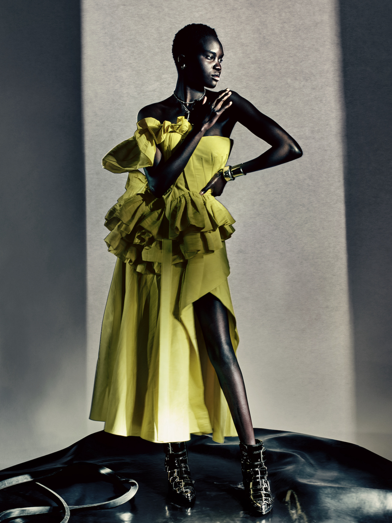  Achenrin wears a bright yellow beetled deconstructed corset dress with an asymmetric skirt, photographed by Paolo Roversi.