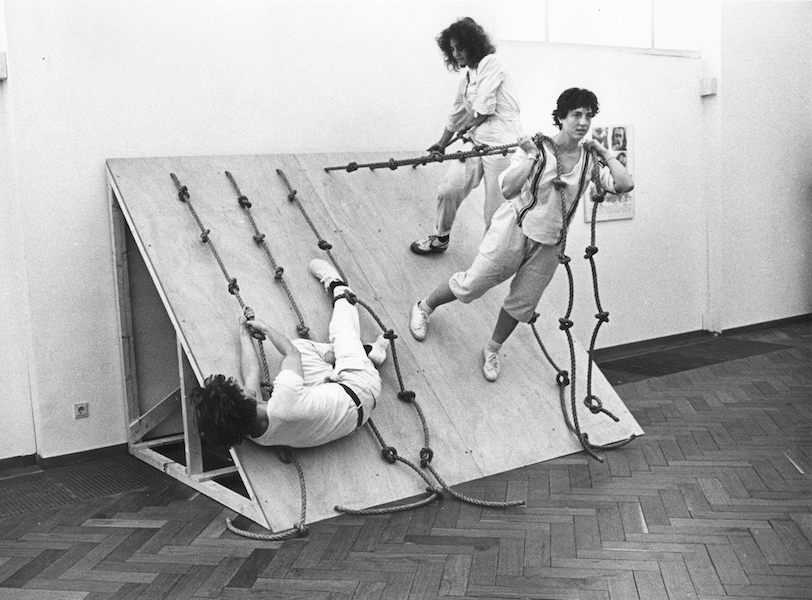  Simone Forti, Slant Board, performed at the Stedelijk Museum, Amsterdam, May 1982, performance with plywood and rope, 10:00 min. The Museum of Modern Art, New York. Committee on Media and Performance Art Funds. © 2022 The Museum of Modern Art, New York.